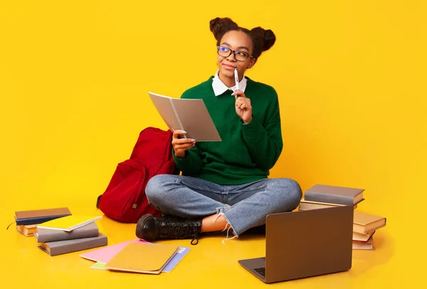 Thoughtful afro teen looking up at studio — Stock Photo, Image