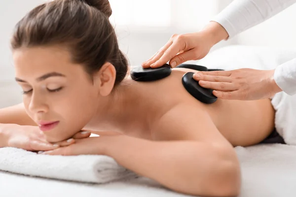 Close-up van vrij gezond meisje het krijgen van hete stenen massage — Stockfoto