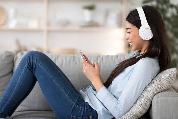 Servicio de música en línea. feliz asiático niñas escuchar su favorito canciones en casa —  Fotos de Stock