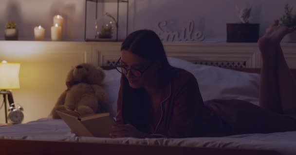 Wanita membaca buku sebelum tidur di tempat tidur — Stok Video