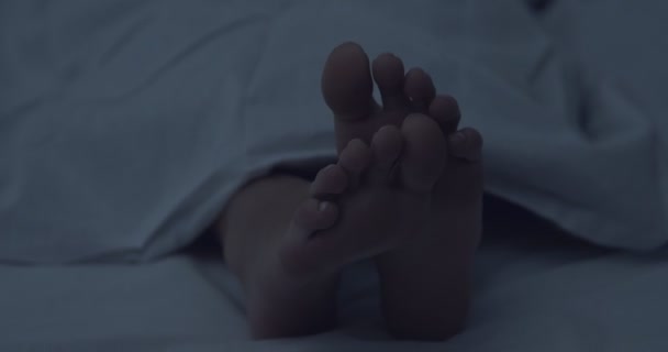 Close up view on female feet under blanket — Stock Video