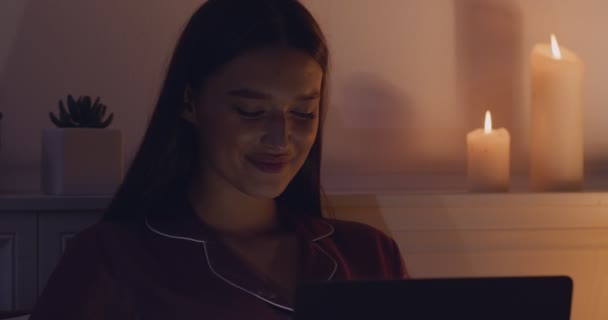 Молода жінка спілкується з хлопцем в Інтернеті в ліжку — стокове відео