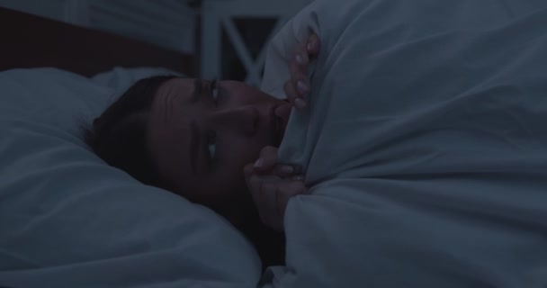 Ragazza preoccupata sdraiata sveglia a letto, che copre il viso con la coperta — Video Stock