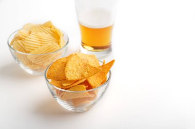 Bira karışımı. Bardakta parlak bira, cips ve cam tabakta cips.