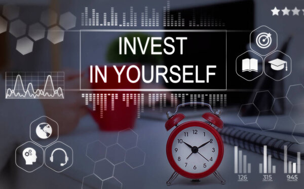 Invest In Yourself Phrase Over Background with Clock On Desk
