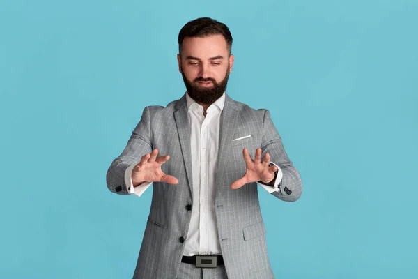 Jovem empresário sério tocando tela virtual interativa em fundo azul, espaço para design — Fotografia de Stock