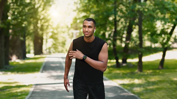 Glücklicher Millennial-Athlet trainiert für Marathonlauf am sonnigen Morgen im Park — Stockfoto