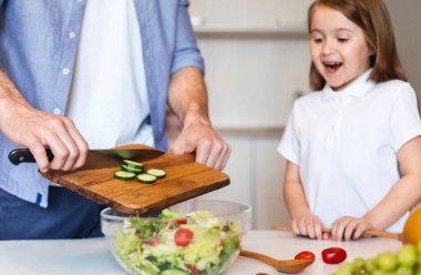 Küçük kızımız mutfakta babasıyla yemek pişiriyor.