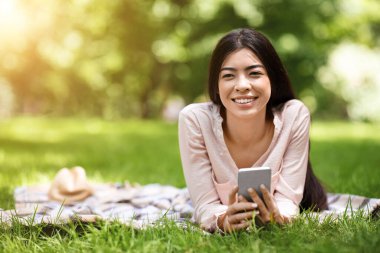 Hayalperest Asyalı Kız Ellerinde Akıllı Telefonla Parkta Kareli Kekede Rahatlıyor