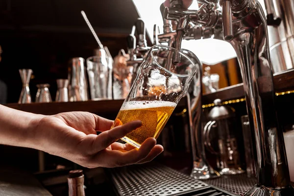 Gießen Sie ein Pint Bier. Barkeeper Hand hält Glas und nimmt Getränk aus dem Zapfhahn — Stockfoto