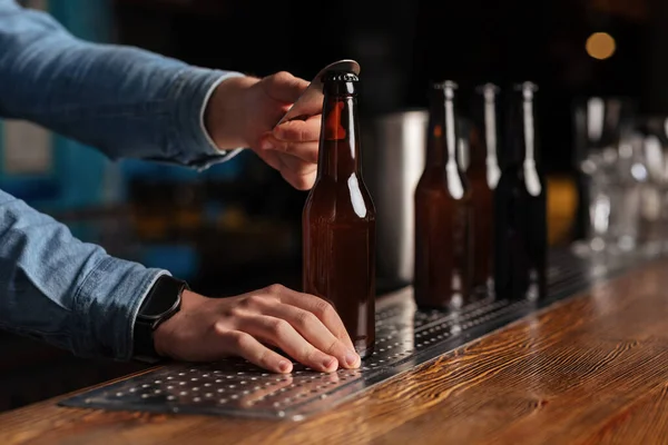 Boissons dans un pub branché. Bouteilles de bière ouvertes sur comptoir de bar en bois — Photo