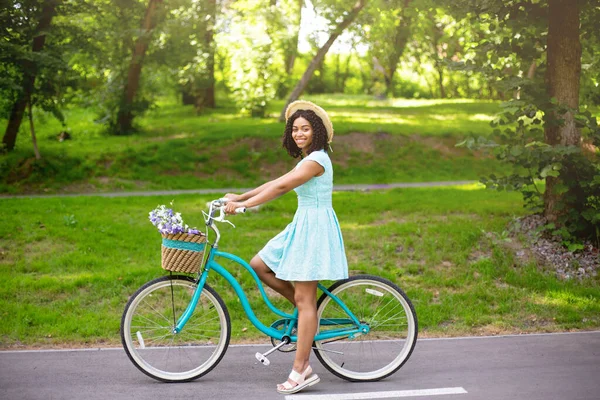 Портрет привлекательной афроамериканской девушки с велосипедом в парке в летний день — стоковое фото
