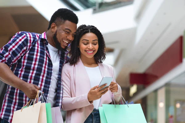 Conceito Cashback. Casal preto feliz com Smartphone verificando conta bancária depois de fazer compras — Fotografia de Stock