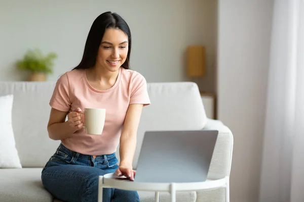自宅でコーヒーを楽しむノートパソコンで映画を見て陽気な女の子 — ストック写真