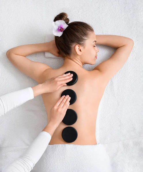 Hot stone massage för ung dam, ovanifrån — Stockfoto