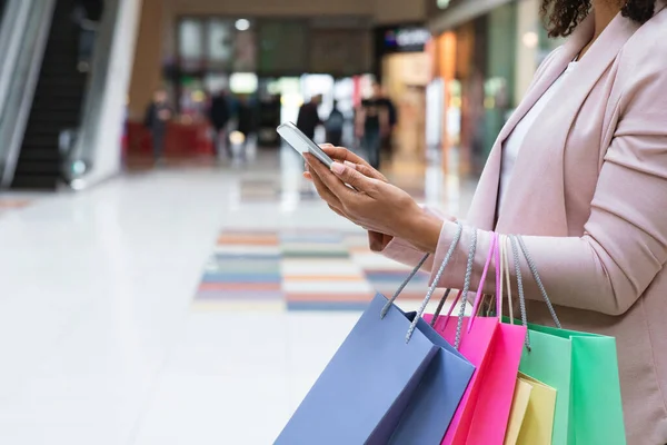 Återbetalningsbonus. Kvinna med Shopper väskor Använda Smartphone I Mall Efter Shopping — Stockfoto