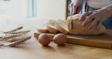 Kırsal masada gevrek ekmek kesen bir kadın.