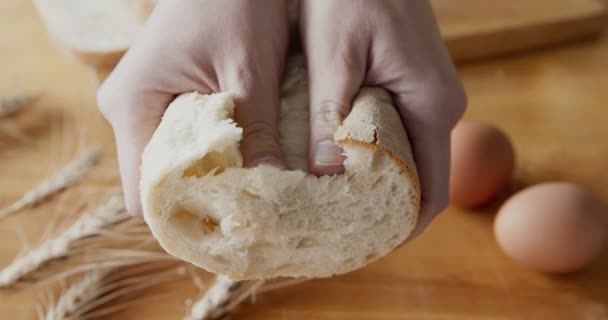 Kobieta łamie pół świeżego chleba. — Wideo stockowe