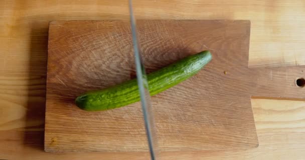 Messer schneidet frische Gurken auf zwei Hälften, Ansicht von oben — Stockvideo