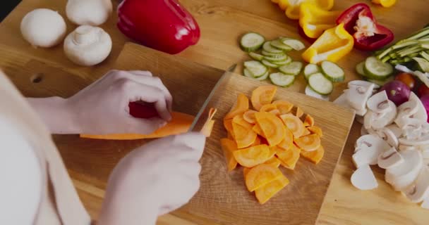 Kvinde skære rå gulerod på køkkenbordet – Stock-video