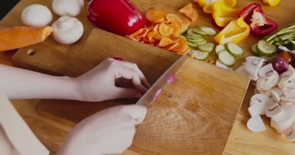 Женщина режет свежую редиску на кухонной доске — стоковое видео