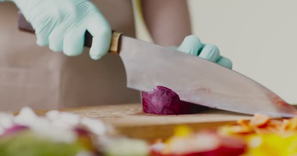 Close-up van vrouwelijke handen in handschoenen snijden biet — Stockvideo