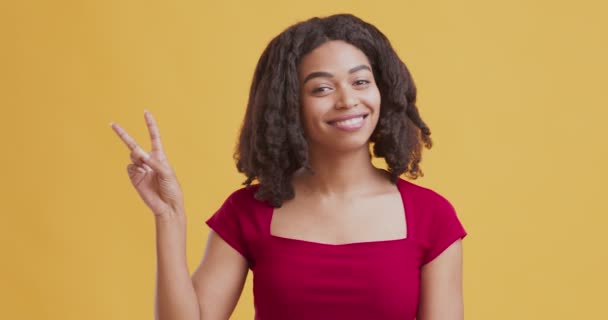 Mutlu Afrikalı Amerikalı kız elini kaldırıyor ve barış işareti yapıyor. — Stok video