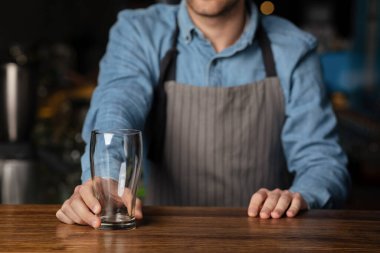 Barda müşteri hizmetleri. Barmen, müşteriye boş bardak veriyor.