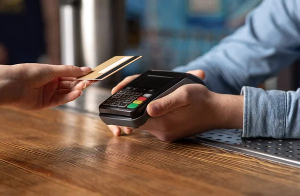 Paiement moderne de la facture dans un pub avec terminal sans contact. Fille applique carte de crédit — Photo