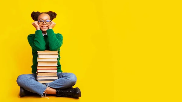 Afro schoolgirl with stack of books at studio — Stock Photo, Image