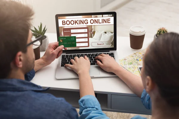 Ζευγάρι κάνει online κράτηση ξενοδοχείου, χρησιμοποιώντας φορητό υπολογιστή — Φωτογραφία Αρχείου