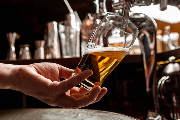 Barda el yapımı bira. Barmen bardaktan su doldurur. — Stok fotoğraf