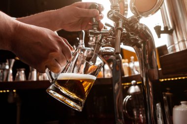 Barmen olarak çalışıyorum. Barmen barın içindeki cam bardaktan bira doldurur.