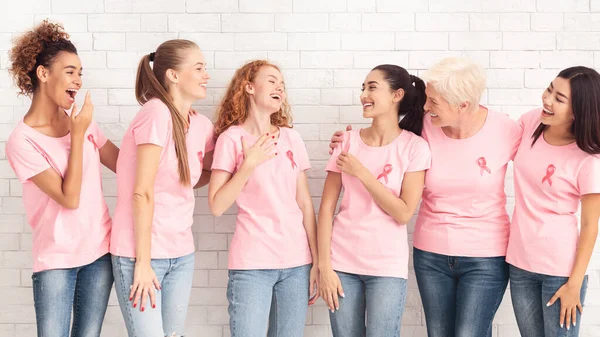 Mujeres del grupo de apoyo contra el cáncer de mama riéndose contra la pared blanca — Foto de Stock