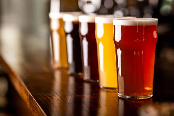 Grande escolha de cervejas. Bebidas de cores diferentes no balcão da barra — Fotografia de Stock