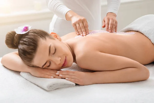 Hermosa dama recibiendo masaje de sal en el spa moderno — Foto de Stock