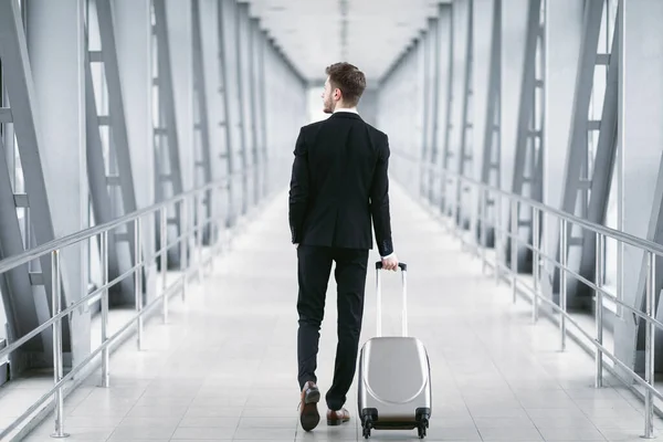 Uomo d'affari urbano a piedi in aeroporto con valigia — Foto Stock