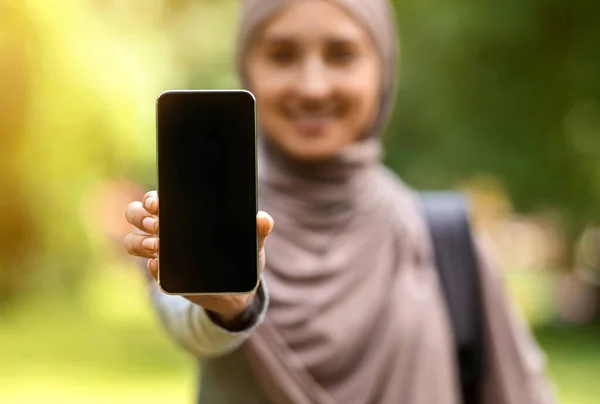 Muchacha musulmana mostrando la pantalla del teléfono inteligente más reciente en blanco —  Fotos de Stock