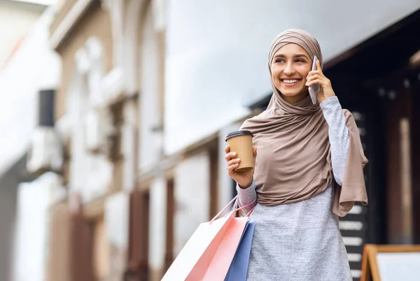 Alışveriş torbalarıyla telefonda konuşan mutlu Müslüman kız. — Stok fotoğraf