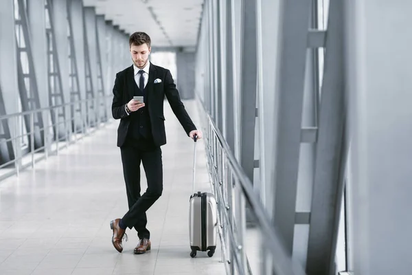 Uomo d'affari urbano messaggiando sul cellulare in aeroporto — Foto Stock