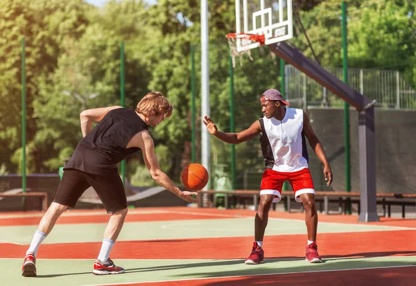 Αφροαμερικανοί και Καυκάσιοι μπασκετμπολίστες που παίζουν παιχνίδι στο υπαίθριο δικαστήριο — Φωτογραφία Αρχείου