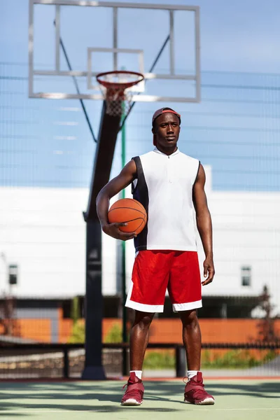 Portrait of young African American sportsman with basketball at outdoor stadium — Stok Foto