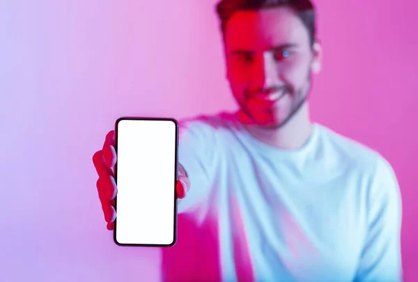 Millennial cara segura telefone touchscreen na mão com tela em branco em luz de néon — Fotografia de Stock