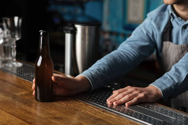 Nachtleven. Barman geeft fles bier zonder label voor de klant — Stockfoto