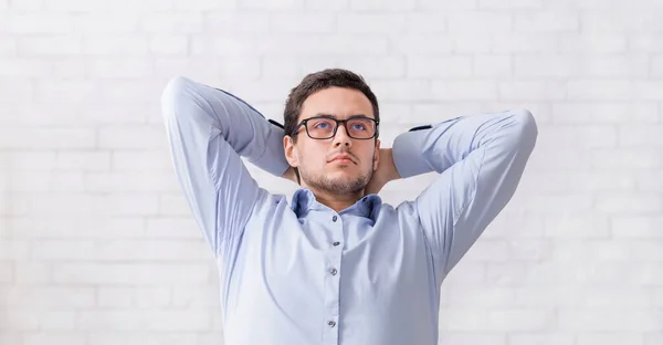 안경을 쓴 피곤 한 남자가 일할 때 손을 위에 얹고 쉬고 있습니다 — 스톡 사진
