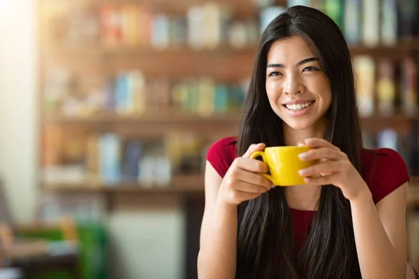 Tijd voor koffie. gelukkig aziatische vrouw genieten van kopje cappuccino in cafe — Stockfoto