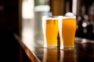 Barda arkadaşlarla buluşacağız. Bardaki tahta barda köpüklü iki bardak light bira.