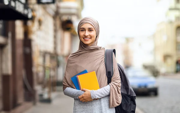 Menina muçulmana indo para a universidade, segurando blocos de notas — Fotografia de Stock