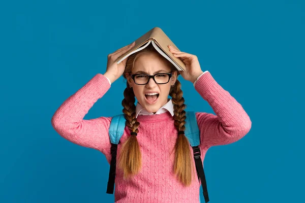 Stor belastning under studietiden. Trött tonåring flicka skriker och täcker sitt huvud med bok — Stockfoto