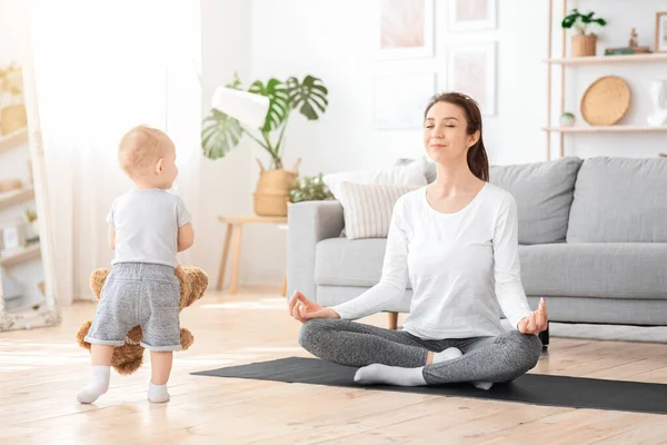 Radzenie sobie z macierzyństwem. Relaksująca mama medytująca ze słodkim maluchem — Zdjęcie stockowe